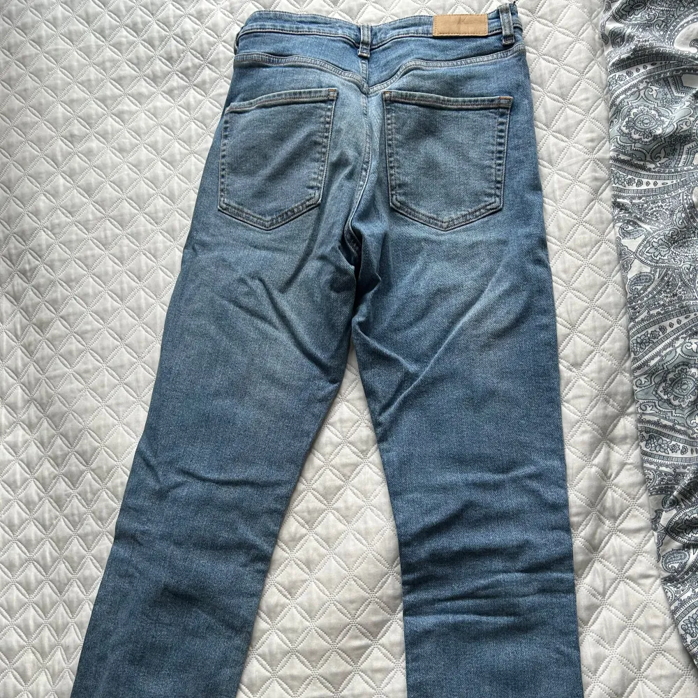 Snygga blå jeansbyxor med en klassisk straight passform. Perfekta för en avslappnad stil. De har en traditionell femficksdesign och en knappgylf.. Farkut & Housut.