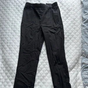 Svarta byxor från Ellos - Snygga svarta byxor från Ellos med elastisk midja för extra komfort. Byxorna har en rak passform och är perfekta för en stilren look. De har diskreta fickor baktill och är tillverkade i ett mjukt material. Aldrig använd 🦋