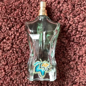  Jean Paul Gaultier Paradise Garden - Säljer en ikonisk Jean Paul Gaultier Paradise Garden. Flaskan är formad som en manlig torso i genomskinligt glas med broderad detalj i blått, gult och vitt framtill. Perfekt för dig som gillar unika och snygga flaskor och parfymen doftar frächt med en somrig doft som kommer at ge dig masor av komplimanger! :)