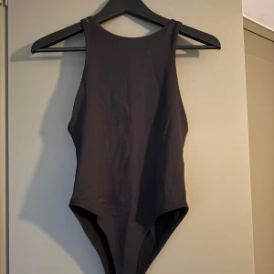 Svart body Zara - Enkel och stilren svart body från Zara med hög halsringning och klassisk passform. Använd en gång. 