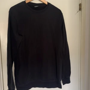 Svart sweatshirt  - En stilren svart sweatshirt från Urban Classics i storlek L. Tröjan har rund halsringning, långa ärmar och ribbade muddar vid ärmslut och nederkant. Perfekt för en clean och avslappnad look. Materialet är mjukt och skönt, troligtvis bomull eller bomullsblandning. Storlek:L! Pris kan diskuteras samt skriv till mig vid eventuella frågor🤩