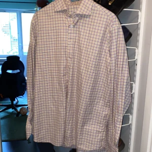 Rutig skjorta från Stenströms, strl 44 - Säljer en klassisk rutig skjorta från Stenströms i storlek 44. Skjortan har mönster i blått, gult och vinrött på vit botten, långärmad och med knappar framtill. Tillverkad i mjuk och lyxig bomull, fitted body-modell. Perfekt för dig som gillar stilrena och färgglada skjortor.