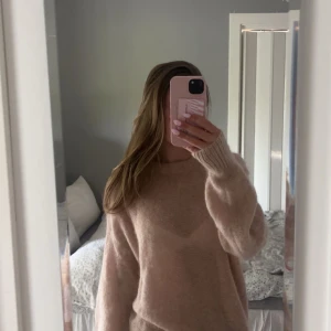 Beige/rosa stickad tröja med loose fit - Supermysig beige stickad tröja med rund hals och långa ärmar. Lite längre passform vilket gör den ännu mysigare! 