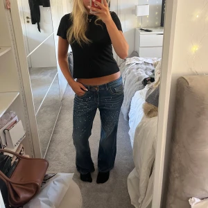 Lågmidjade bootcut jeans - Lågmidjade bootcut jeans med glitterstenar. Superfina men tyvärr för stora. Midjemått: 39, innerbenslängd: 72