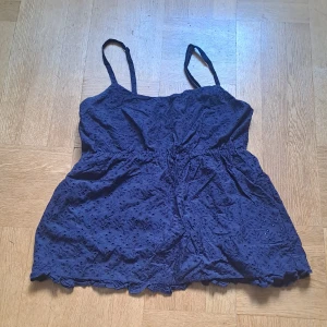 Mörkblå topp - Supersöt mörkblå topp från Lager 157 med smala axelband och broderade blommor över hela tyget. Toppen har smockad rygg och en lätt volangkant nertill. 🩷😊 Pris är diskuterbart 