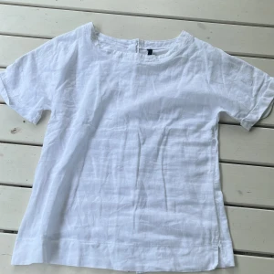 Vit topp - Fin vit topp från united colors of benneton. Framsidan är gjord av lin och baksidan av stretchigt T-shirt tyg. Framsidan är på bild tre och baksidan på bild 1 men man skulle kunna ha på andra hållet om man vill ha knapparna på framsidan. Priset går att diskuteras och det är mina bilder.