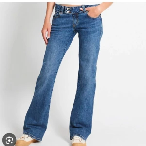 Blå bootcut jeans - Storlek S Short lenght. Populära blå bootcut jeans från lager 157 med dubbla knappar i midjan och stora framfickor. Jeansen har låg midja och klassisk denimlook, perfekta för dig som gillar retrovibbar och vill ha en cool siluett. Använd några gånger men bra skick. 