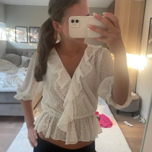 Vit omlottblus med volang och prickar - Supersöt vit blus från van den rock!!