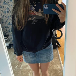 Svart Disney Fantasia sweatshirt - Svart sweatshirt med tryck av Mickey Mouse från Fantasia på bröstet. Tröjan har rund hals, långa ärmar och en relaxed passform. Perfekt för dig som gillar Disney och vill ha en chill och snygg look.