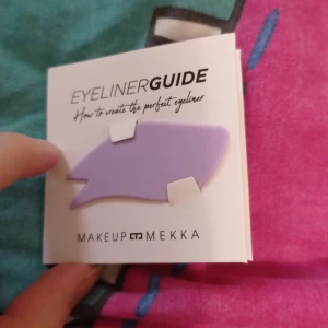 Eyeliner guide från Makeup Mekka - Säljer en lila eyeliner guide i mjukt silikon från Makeup Mekka. Perfekt för att skapa olika eyeliner-looks med både raka och böjda kanter. Kommer med instruktioner för flera stilar, superenkel att använda för skarpa linjer och vingar.