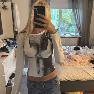 Vit långärmad tröja med print - Säljer en vit långärmad meshtröja med svart grafiskt print framtill. Tröjan har väldigt stretchigt material. Nästan aldrig använd💘