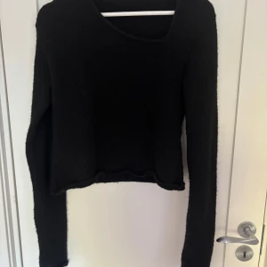 Svart stickad tröja från LeGer - Svart stickad tröja från LeGer by Lena Gercke. Tröjan har lång ärm, rund halsringning och en något croppad passform. Perfekt för dig som gillar en enkel men stilren look. Mjuk och skön att bära under kyligare dagar.