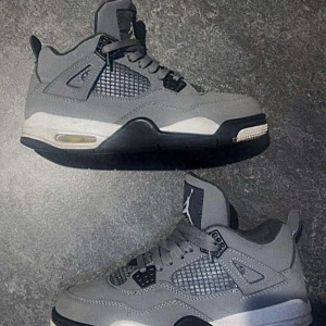 Jordan 4 Retro Cool Grey - Snygga Jordan 4 Retro Cool Grey sneakers i grått med svarta, vita och gula detaljer. Skorna har klassisk meshpanel på sidorna, snörning och en robust sula med synlig luftdämpning. Perfekta för dig som gillar streetwear och vill sticka ut med en ikonisk modell. Dom kommer även med crease skydd! 