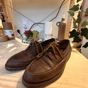 Bruna loafers i skinn - Klassiska bruna loafers i skinn med rund tå och snörning framtill. Snygga sömmar runt ovandelen och robust, mönstrad sula för extra grepp. Perfekta för dig som gillar en tidlös och stilren look.