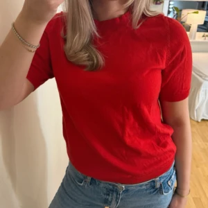  Stickad kortärmad tröja  - Snygg röd stickad tröja från Lindex i storlek S. Tröjan har korta ärmar, rund halsringning och är gjord i en mjuk blandning av lyocell och polyester. Använd en gång!💘