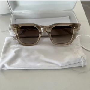  Chimi  04 - Snygga solglasögon från Chimi med transparent beige båge och fyrkantig form. Glasen är bruna och ger en cool vibe. Perfekta för att lyfta din stil under soliga dagar. Kommer med originalfodral och tygpåse.
