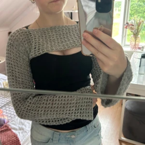 Grå virkad bolero med vida ärmar - Säljer en grå virkad bolero. Tröjan har långärmade, vida ärmar och en croppad passform som sitter snyggt över axlarna. Perfekt över ett linne till exempel. Kan även virkas på beställning. Skriv för frågor!💗