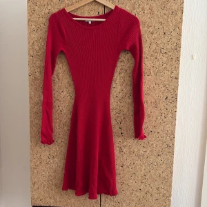 Röd ribbad klänning från Bubbleroom - Supersnygg röd ribbad klänning från Bubbleroom i figurnära modell. Klänningen har lång ärm, rund halsringning och är i kort längd. Perfekt för dig som gillar en enkel men ändå iögonfallande stil.