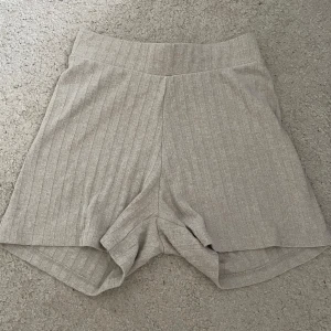 Beigea ribbade shorts från Zara - Superbekväma beigea shorts med ribbad struktur och hög midja från Zara. Perfekta för varma dagar eller chill hemma. Mjukt material och enkel design som passar till allt.