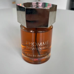 Yves Saint Laurent L'Homme EdP 100ml - L'Homme Eau de Parfum från Yves Saint Laurent. 100ml flaska, har använt max typ 5ml. Har lådan också och tror jag sparade kvittot. Köpte på Kanarieöarna när jag var där i vintras.