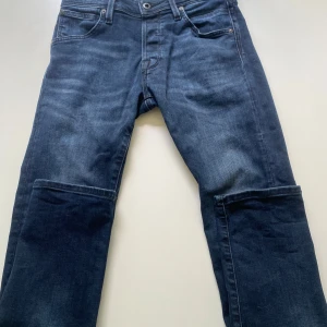 Mörkblå slim jeans från Jack & Jones - Snygga mörkblå jeans från Jack & Jones, modell Slim/Glenn. Jeansen har klassisk femficksdesign, smal passform och är tillverkade i stretchig denim för extra komfort. Perfekta för dig som gillar en modern och stilren look.