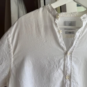 Vit linneskjorta från Bläck, S - Fräsch vit linneskjorta från Bläck i storlek S. Långärmad skjorta med knappar hela vägen och ståkrage. Ganska genomskinlig, tunn och härlig d.v.s sval och luftig. Något liten i storlek. Den är lite missfärgad efter solkräm men jag har tvättat den ordentligt.