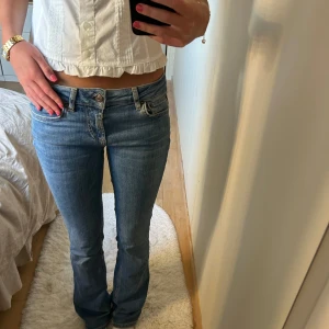 Blå bootcut jeans med låg midja - Super snygga lågmidjade jeans från Zara!💞Dom är i storlek 34. Jeansen har lite slitningar längst ner men inget som man lägger märke till. (se sista bilden)💞💞Säljer då dom tyvärr inte kommer till användning. Skriv om du har några frågor!