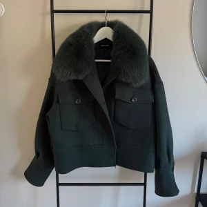 Grön jacka med pälskrage från Meotine - Snygg grön jacka från Meotine med en lyxig pälskrage. Sparsamt använd. Storlek S/M. Nypris 3000 kr