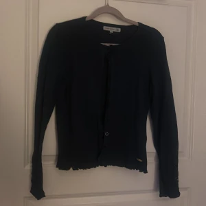 Blå kofta från Flash Woman - Säljer en stilren svart kofta från Flash Woman. Koftan har långa ärmar med knappar vid ärmsluten och en knappstängning framtill. Perfekt för att hålla sig varm och snygg under kyligare dagar. Pris kan diskuteras!