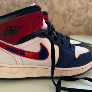 Air Jordan 1 Mid Rush Blue University Red - Snygga Air Jordan 1 Mid i färgerna Rush Blue och University Red. Riktigt bra skick, endast använt ett fåtal gånger. Ordinarie pris: ca 4000kr 