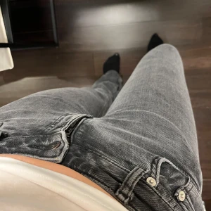 Grå jeansbyxor - Snygga grå jeansbyxor med en klassisk design. De har en normal passform och är tillverkade i jeansmaterial. Byxorna har en dragkedja och knappar framtill samt fickor på sidorna. Reva på sidan tyvärr men går att sy