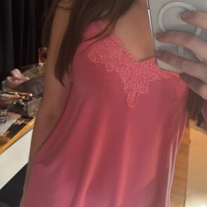 Rosa linne från Amisu - Säljer ett linne från Amisu i en sjukt snygg färg med spetsdetaljer vid halsringningen. I storlek s. 