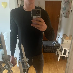 Mörkgrå tröja från Uniqlo - Säljer en stilren mörkgrå tröja från Uniqlo. Tröjan har en klassisk rund hals och långa ärmar, perfekt för en minimalistisk look. Tillverkad i ett mjukt material som ger en bekväm passform. 