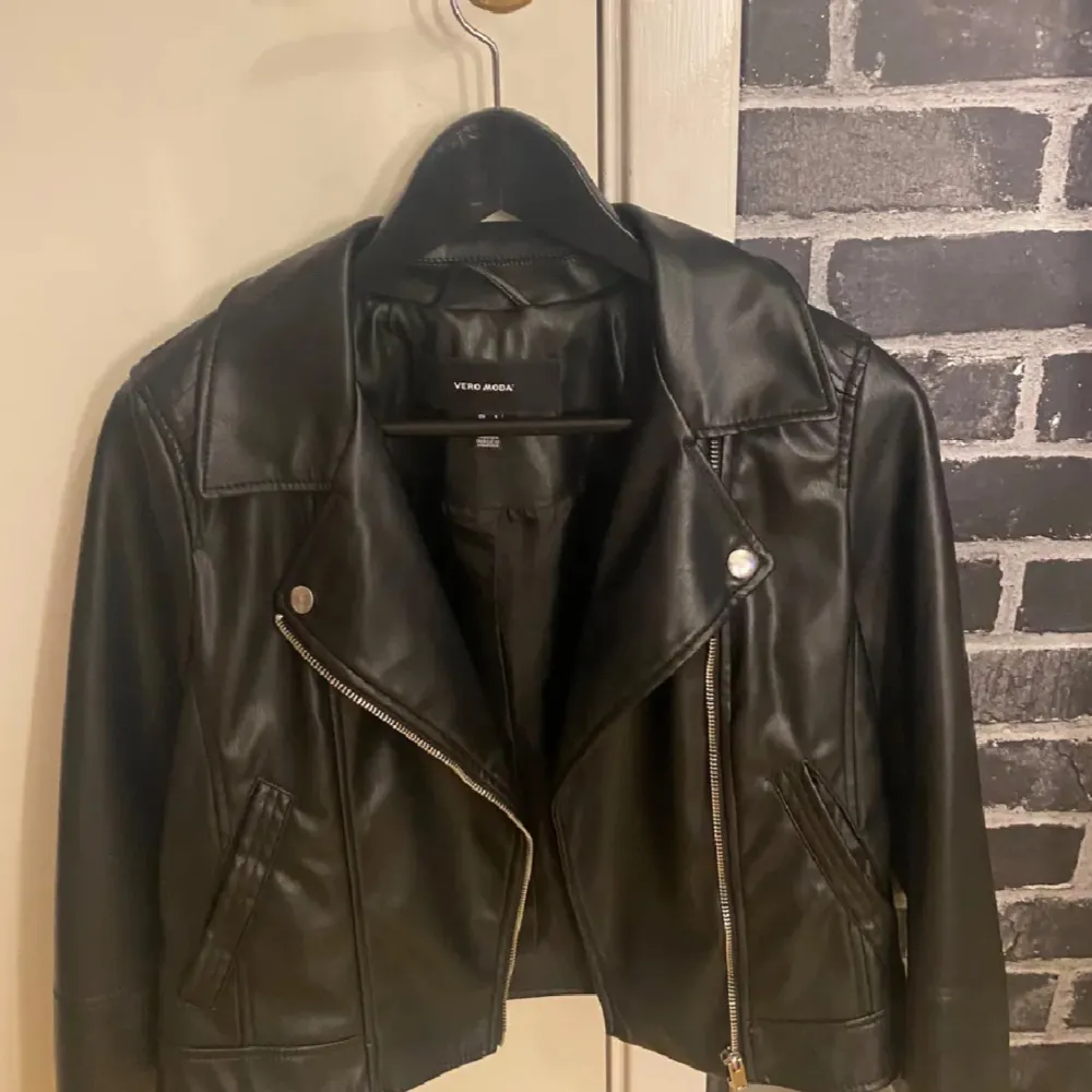 Snygg svart skinnjacka från Vero Moda i storlek S. Jackan har en klassisk bikerstil med dragkedja och knappar. Perfekt för en cool och stilren look. Knappt använd använt kanske 4 ggr. Passar xs, bra skick . Takit.