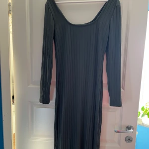 Mörkgrön ribbad klänning från Bubbleoom - Snygg mörkgrön klänning från Bubbleoom i ribbat material. Klänningen har en åtsittande passform och långa ärmar, i nyskick. Strl M. 