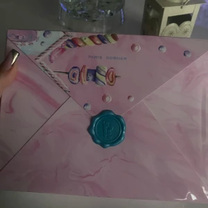 Marshmallow Blush Parfym från Paris Corner - En söt och lekfull parfymflaska från Paris Corner, formad som en marshmallow i rosa och guld. Flaskan har en rund topp och ett dekorativt guldlock. Förpackningen är fantasifull med pastellfärger och godisinspirerade detaljer.