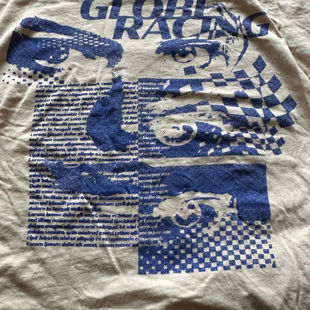 Säljer en beige t-shirt från Divided med ett coolt blått tryck som har racingtema. T-shirten är kortärmad och har en normal passform. Perfekt för en avslappnad stil!. T-paidat.