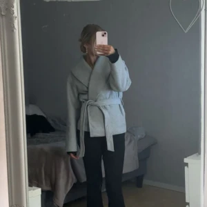 Grå kappa med knytband - Snygg grå kappa med knytband i midjan. Perfekt för höst och vår. Säljer pågrund av att den inte kommer till användning💕