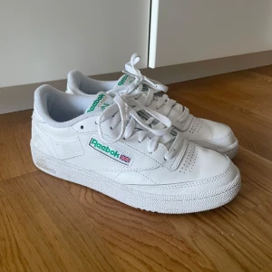 Vita sneakers från Reebok - Säljer ett par klassiska vita Reebok sneakers med gröna detaljer.