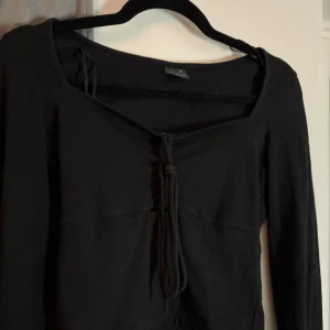 Långärmad topp med knytning - !SE BIOGRAFI INNAN KÖP! Säljer denna svarta långärmade tröja från Gina Tricot. Slits i ärmarna (bild 2) och ar knytning framtill. För fler bilder hör av er!