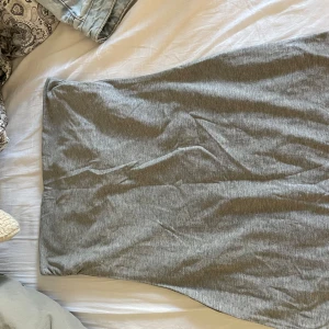 Klänning - Ny klänning med lapp kvar. Aldrig använd. Grå, storlek m från h&m. Utan axelband. Med resår och dubbeltyg vid bröstet.