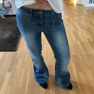 Low waist bootcut jeans - Säljer ett par asnice mörkbli bootcut jeans med slitningar och unika fickor. Storlek 36, använda ett fåtal gånger.💘