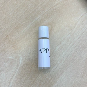 Apple Noir - En liten parfymflaska, flaskan är cylindrisk och har en vit kork med roll-on funktion. Perfekt för att ta med sig på resan eller ha i fickan. Doften är fräsch äpple med en touch av citrus.