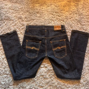 Nudie Jeans Thin Finn - Snygga mörkblå jeans från Nudie i modellen Thin Finn. Jeansen är i väldigt fint skick, 9/10 använda fåtal gånger. Skriv gärna över frågor och funderingar, priset kan diskuteras.