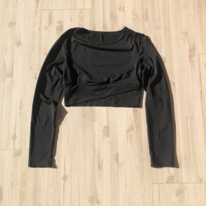 Svart croppad långärmad träningströja - Snygg svart croppad träningstopp med långa ärmar. 