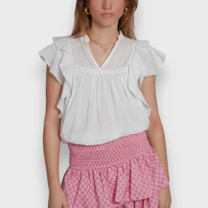 Rosa kortkjol med volang - Söt rosa kortkjol med små vita mönster, volangdetaljer och inbyggda shorts. Kjolen har en elastisk midja för en bekväm passform. Perfekt för en somrig look! Hör av er vid frågor!☀️💕