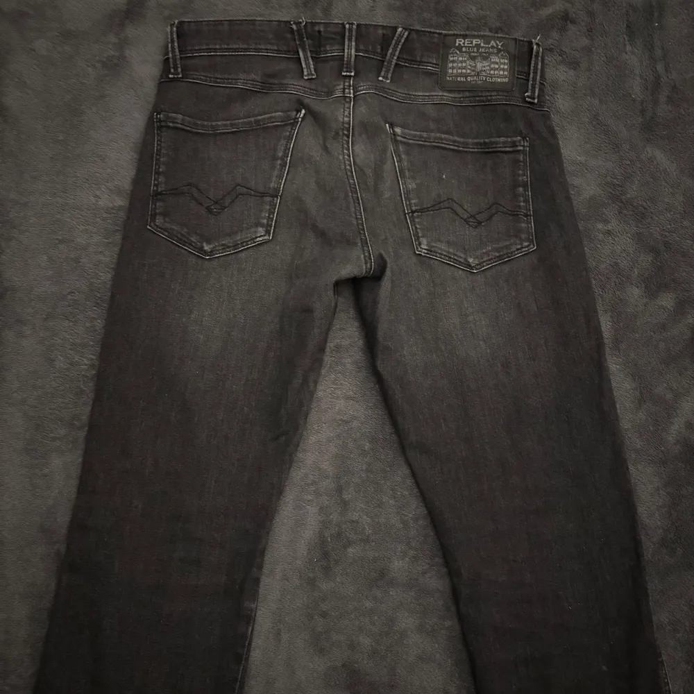 Snygga svarta jeans från Replay, modell Anbass. De har en slim fit och är perfekta för en stilren look. Klassisk femficksdesign med dragkedja och knapp. Passar bra till både vardag och mer uppklädda tillfällen.. Farkut & Housut.