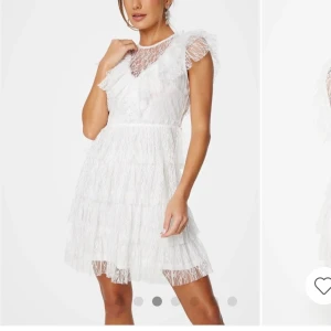 Vit spetsklänning med volanger - Säljer denna fina studentklänning. Aldrig använd eller ens provad! Charmig vit spetsklänning med volanger och korta ärmar. Klänningen har en v-ringad design med ett transparent spetslager över axlarna och bröstet. Perfekt för sommarens festligheter.