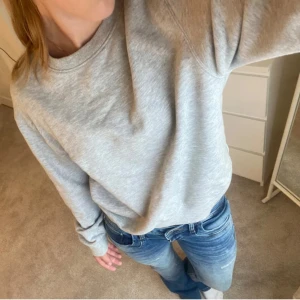 Grå sweatshirt - Säljer en klassisk grå sweatshirt med rund hals och långa ärmar. Perfekt för en avslappnad stil. Tröjan är mjuk och bekväm, idealisk för vardagsbruk.