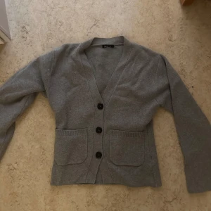 Figursydd kofta Gina tricot - Säljer en stilren figursydd kofta från Gina tricot.  Storlek S